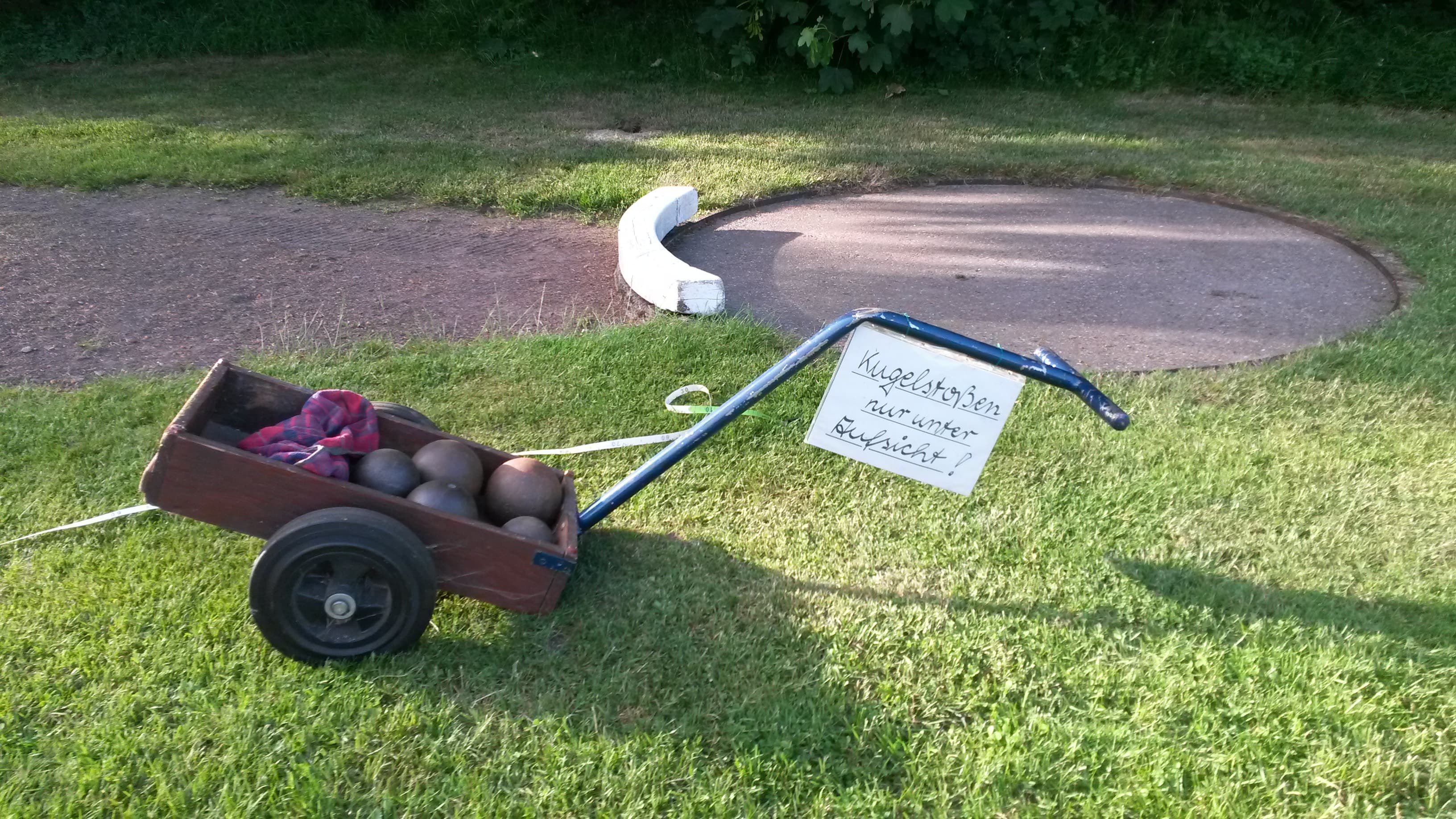 Kugelstoßanlage mit Bollerwagen voller Kugeln