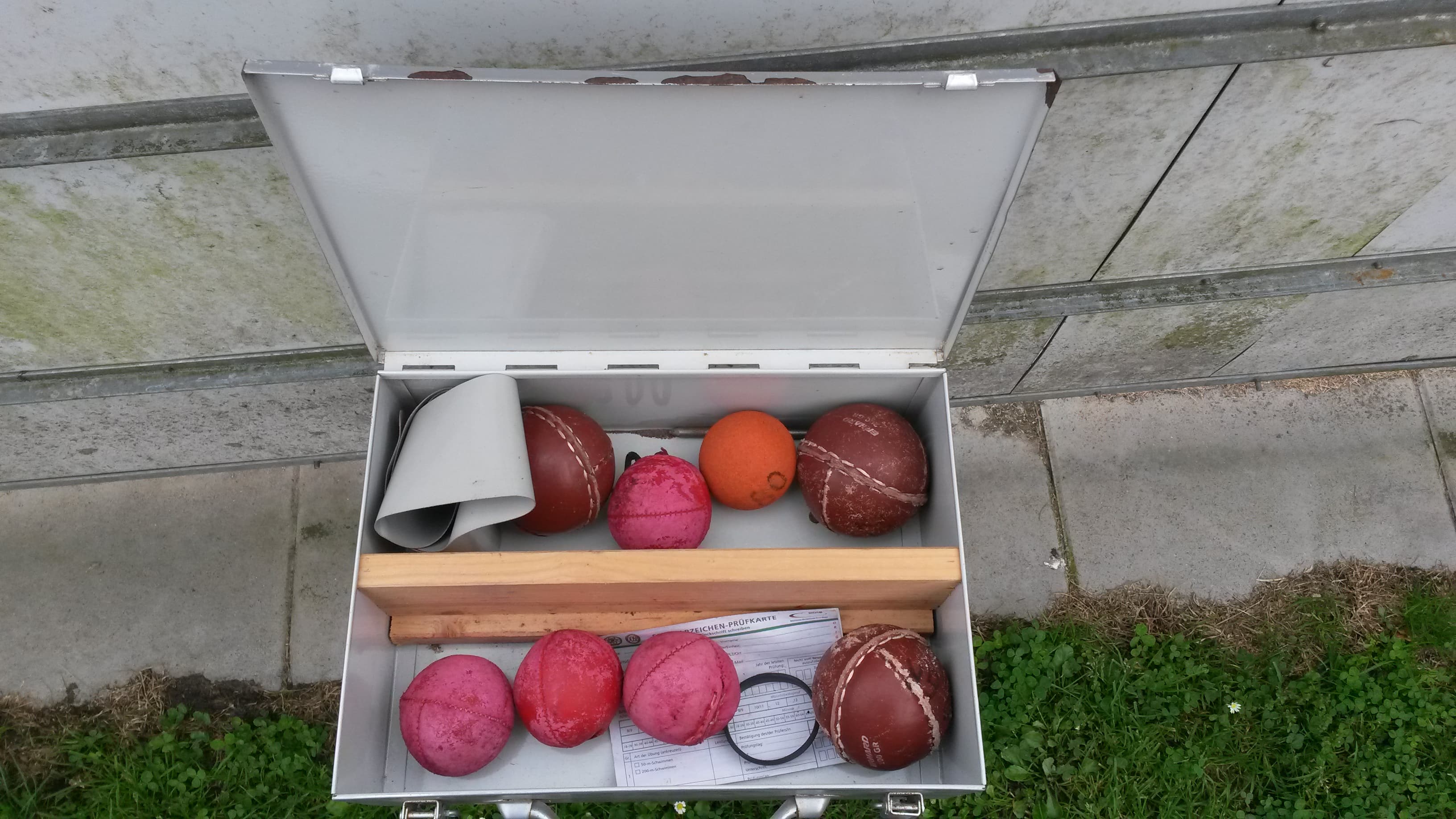 Materialkiste mit Wurfbällen und Sportabzeichen-Prüfkarte